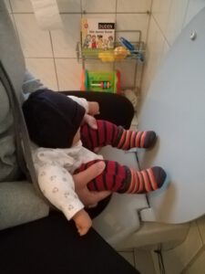 Abhalten rückwärts auf der Toilette